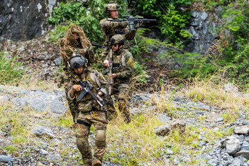 Naklejka premium Military training in a rocky area with soldiers preparing for action