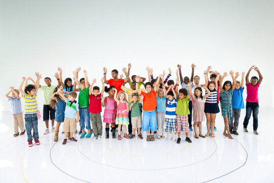 Diverse children raising hands joyfully
