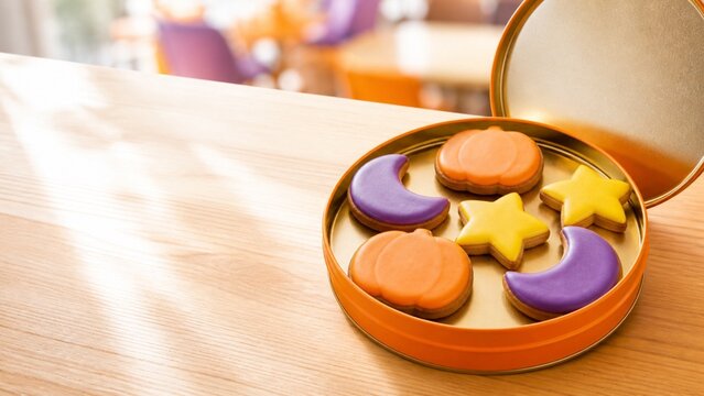 丸い缶に並べた色鮮やかなハロウィンクッキー 秋の洋菓子と広い余白