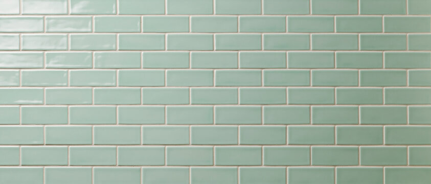 Close-up of a perfectly aligned seamless pattern of shiny, rectangular mint green subway tiles with light grey grout, creating a clean, modern, and minimalist backdrop ideal for