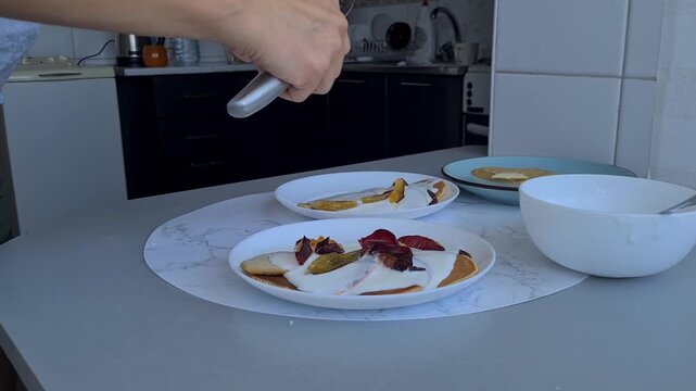 Making dessert with fruits and cream in a kitchen at home