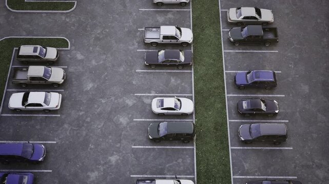 Aerial view parking lot green median, central grass strip and planted verge separating rows of cars, eco design cues, stormwater management implication,