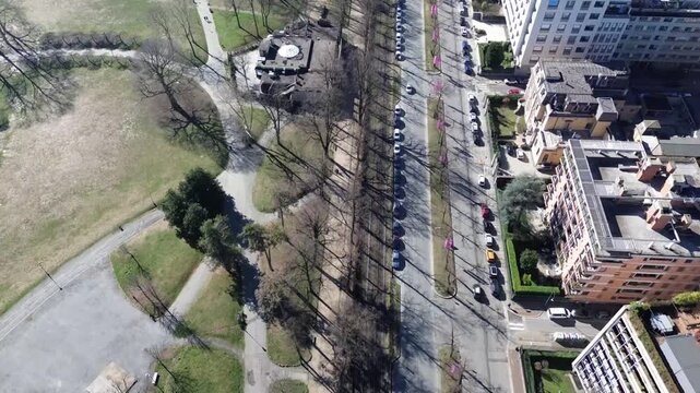 Symmetrical drone view following Corso Vittorio Emanuele boulevard towards Intesa Sanpaolo skyscraper and snowy Alps, Turin, Italy