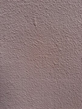 Muted purplish red rough textured painted wall