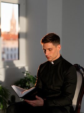 Priest reading Bible in sunlight
