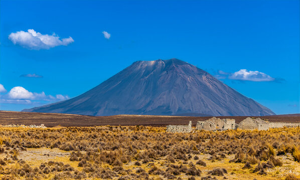 A view across high altitude arid grasslands towards El Misti volcano in the Andes mountains in southern Peru in the dry season