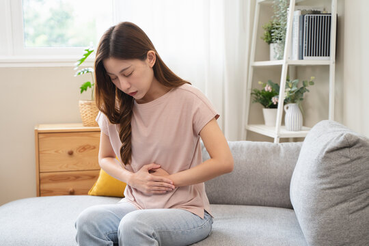 person feeling stomach pain menstruation on the bed.