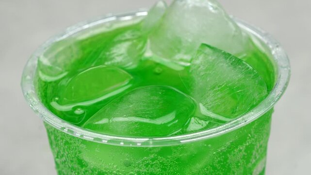 soft drink green pouring with ice cubes and bubbles, 