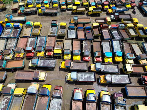 Aerial view of many colorful trucks parked in a large muddy lot in Dhaka, Dhaka Division, Bangladesh.