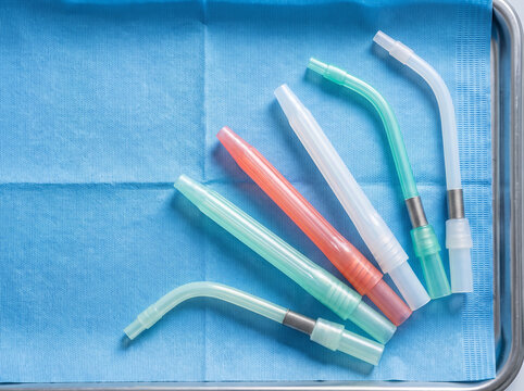 Dental Saliva Ejector and Suction Tips Arranged on Sterile Tray in Clean Minimal Clinical Still Life