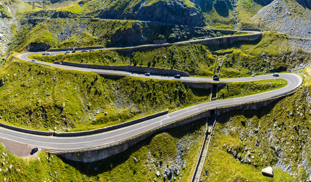 Curving Alpine Road Cutting Through Green Carpathian Mountains. Mountain Infrastructure and Serpentine Highway. A road with successive serpentines