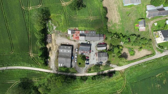 Nadir farmstead with barns, rusty roofs, cars and woodpile