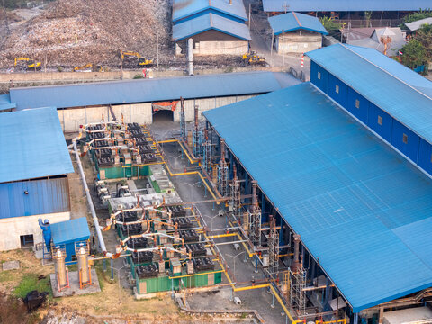 Aerial view of an industrial facility with blue-roofed buildings, complex piping systems, and machinery in Surakarta, Central Java, Indonesia.