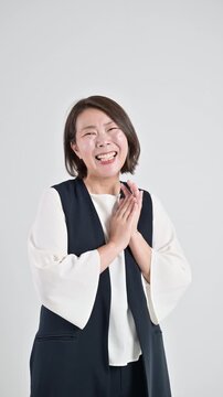  [スローモーション]標達成を喜び笑顔で感謝するありがとうポーズ　成功と喜ぶを表現するポートレート楽しそうなお母さんのような40代の女性の縦動画