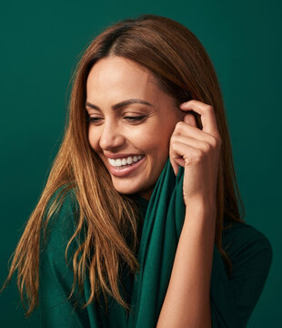 Happy woman with white teeth smiling against green background