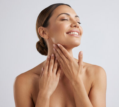 Beautiful smiling woman touching clean healthy skin on neck