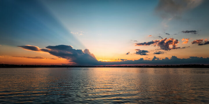 Sunrays breaking through clouds over lake