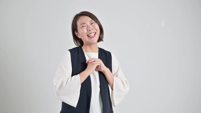  [スローモーション]標達成を喜び笑顔で感謝するありがとうポーズ　成功と喜ぶを表現するポートレート楽しそうなお母さんのような40代の女性の動画
