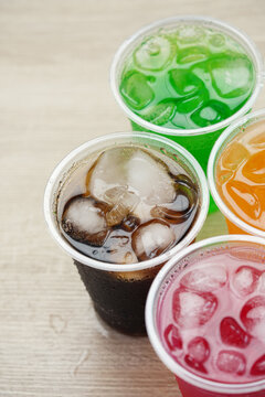 Soft drinks and fruit juice mixed with soda high in sugar have a negative effect on physical health. vertical.	