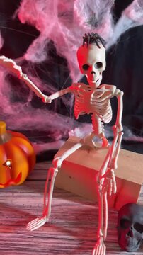 Creepy skeleton display with glowing pumpkin and cobweb Halloween decor