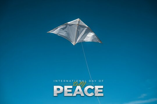 White kite flying in clear blue sky with the word Peace written below