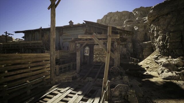 Rugged wild west miner camp gateway under high sun with rocky approach, shuttered shack and stacked planks suggesting supply route and hardworking frontier
