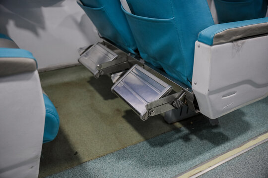 Blue train seats with foldable footrests. The cabin interior features soft color tones and a functional design. Ideal for a travel theme.