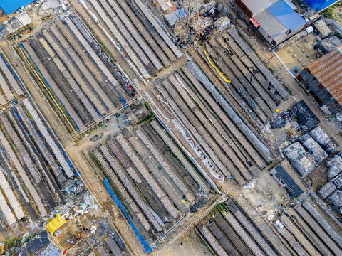 Aerial view of fish drying yards in Bakalia, featuring rows of racks, workers tending to the catch, and industrial structures in Chattogram, Chittagong Division, Bangladesh.