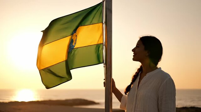 Woman holds environmental flag with earth symbol at sunset beach. Green flag shows globe for sustainability. Woman promotes environment with flag at beach. Earth flag waves at sunset for ecology.