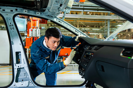 Asian Factory Worker Inspecting Car Interior on Automotive Assembly Production Line