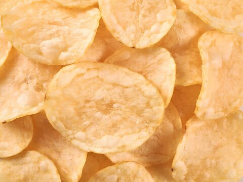 Close-up of crispy potato chips in a pile for snack advertising