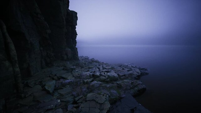 Rocky promontory under surreal purple light, textured foreground leading to calm sea, violet gradient sky, isolated mood and tactile coastal detail with low