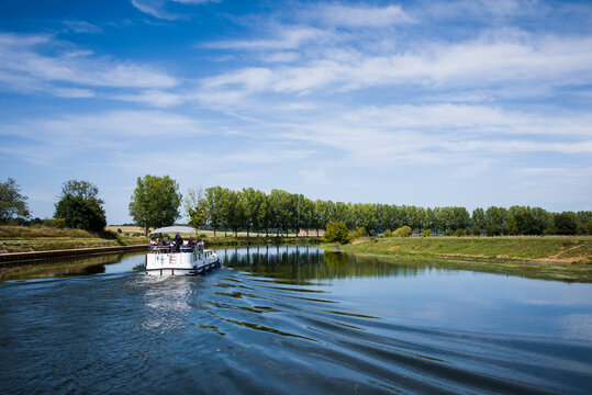 Bateau de croisi&egrave;re sur un canal. Vacances sur une voie navigable. Se d&eacute;placer en bateau. Petit bateau sur l'eau.