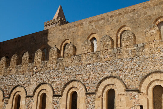 Norman-Arab stone facade of the Cefalu cathedral with arched details