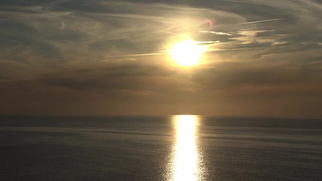 Golden sun setting over the Baltic Sea with lens flare