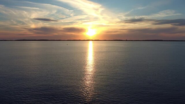 Golden sunset sun reflecting over calm ocean water