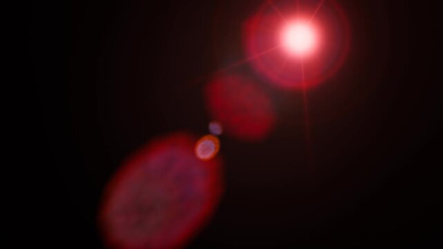 A bright red lens flare and glowing light effect on black background