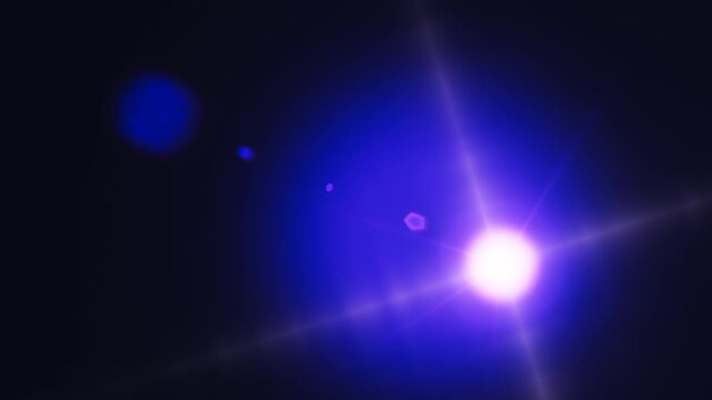 A bright blue lens flare effect glowing intensely against a dark background