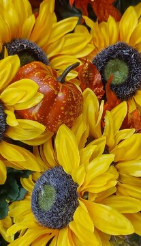Vibrant autumn background with macro yellow sunflowers and bright orange pumpkin