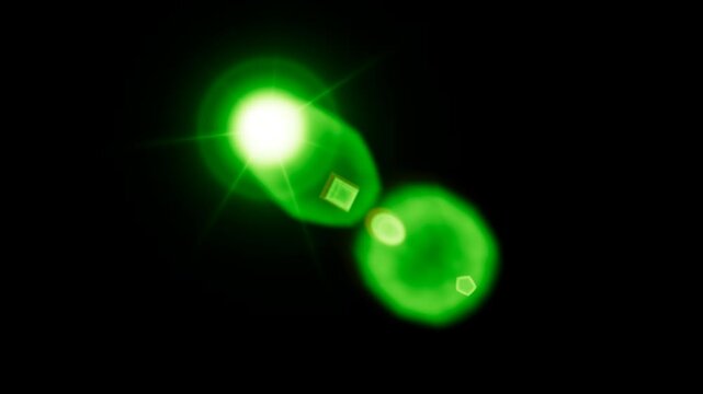 Vibrant green lens flare effect glowing brightly against a solid black background