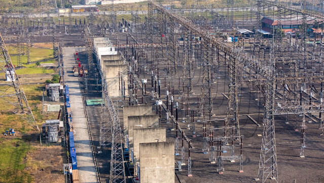 Aerial view of an electrical substation with high-voltage power lines, metal towers, and transformers in an industrial facility Klaten, Central Java, Indonesia.