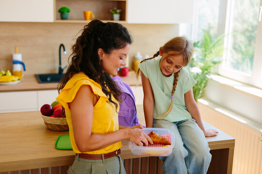 Mother preparing a homemade lunch for daughter before school