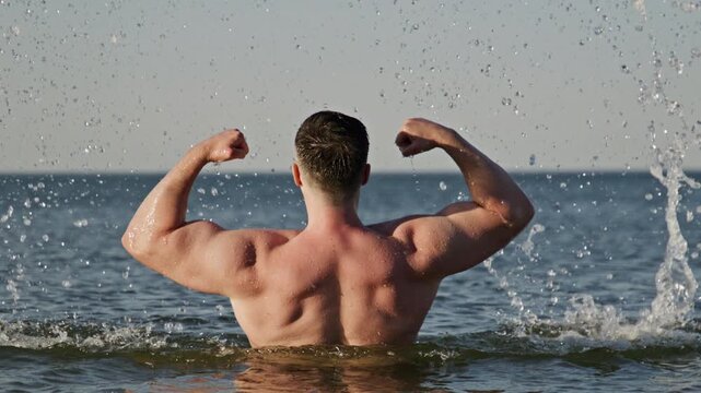 Man back poses near sea. Man torso shows healthy fitness. Strong man concept shows endurance. Shirtless man body looks powerful.