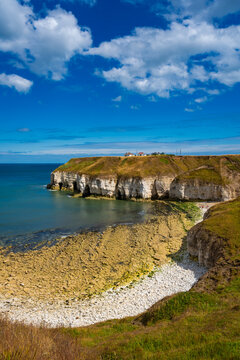 Scenic North Landing bay with white chalk cliffs, rocky beach and blue North Sea at Flamborough Head on the Yorkshire coast, England.