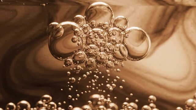 Abstract macro closeup of rising golden liquid bubbles and fluid swirls