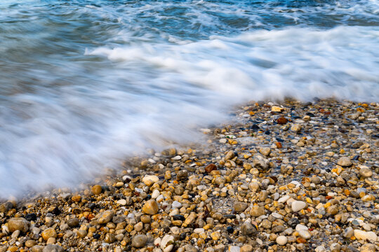 Waves washing over a colourful pebble beach at North Landing, Flamborough Head on the Yorkshire coast, England.