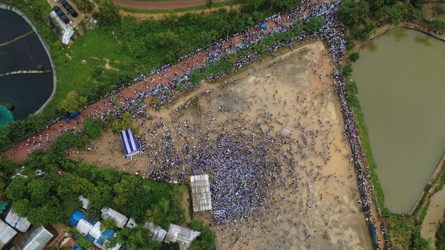 Cox's Bazar, Chittagong Division, Bangladesh - 25 August 2026: Aerial view of a large crowd gathered at the Rohingya refugee camp, with makeshift shelters, ponds, and surrounding greenery.