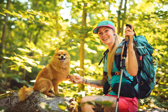 woman trekking in the forest. Traveling activity with dog