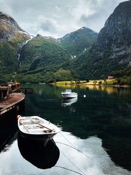 Scenic Eikesdalsvatnet lake with boats and mountains water reflections in Norway, tranquil summer landscape in More og Romsdal with peaceful nature beautiful Scandinavian travel destination