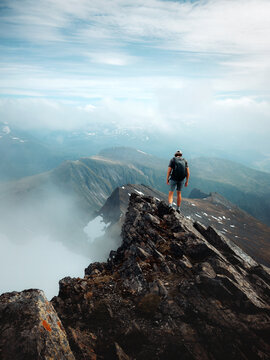 Man climbing mountain summit in Norway travel extreme vacations in Sunnmore Alps adventure trip outdoor healthy lifestyle, active traveler mountaineering solo freedom exploration motivation